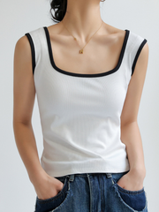 Woman wearing white Wide-Edge Tank Top from Marini's Old Money Collection with black trim and paired with blue jeans.