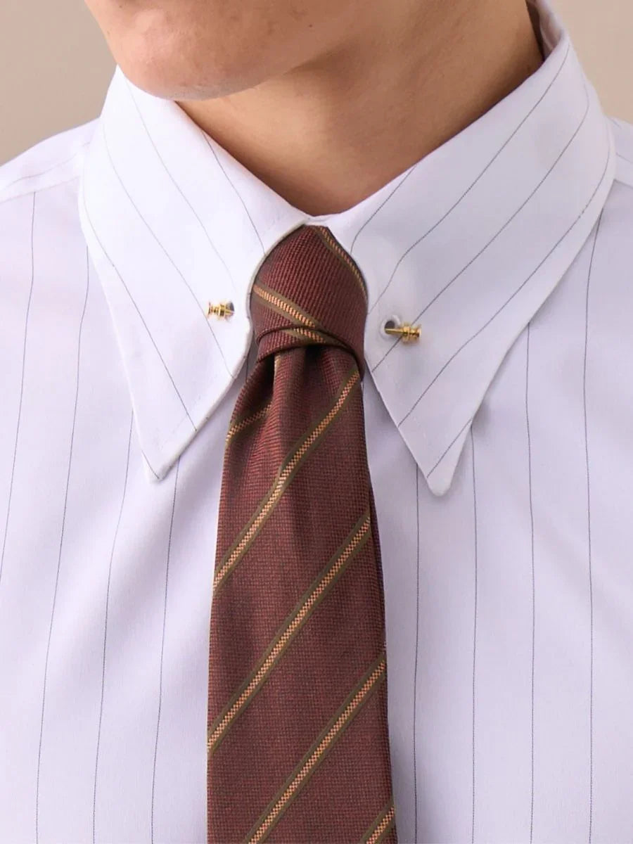 Close-up of white pinstripe dress shirt with gold collar pins and maroon striped necktie