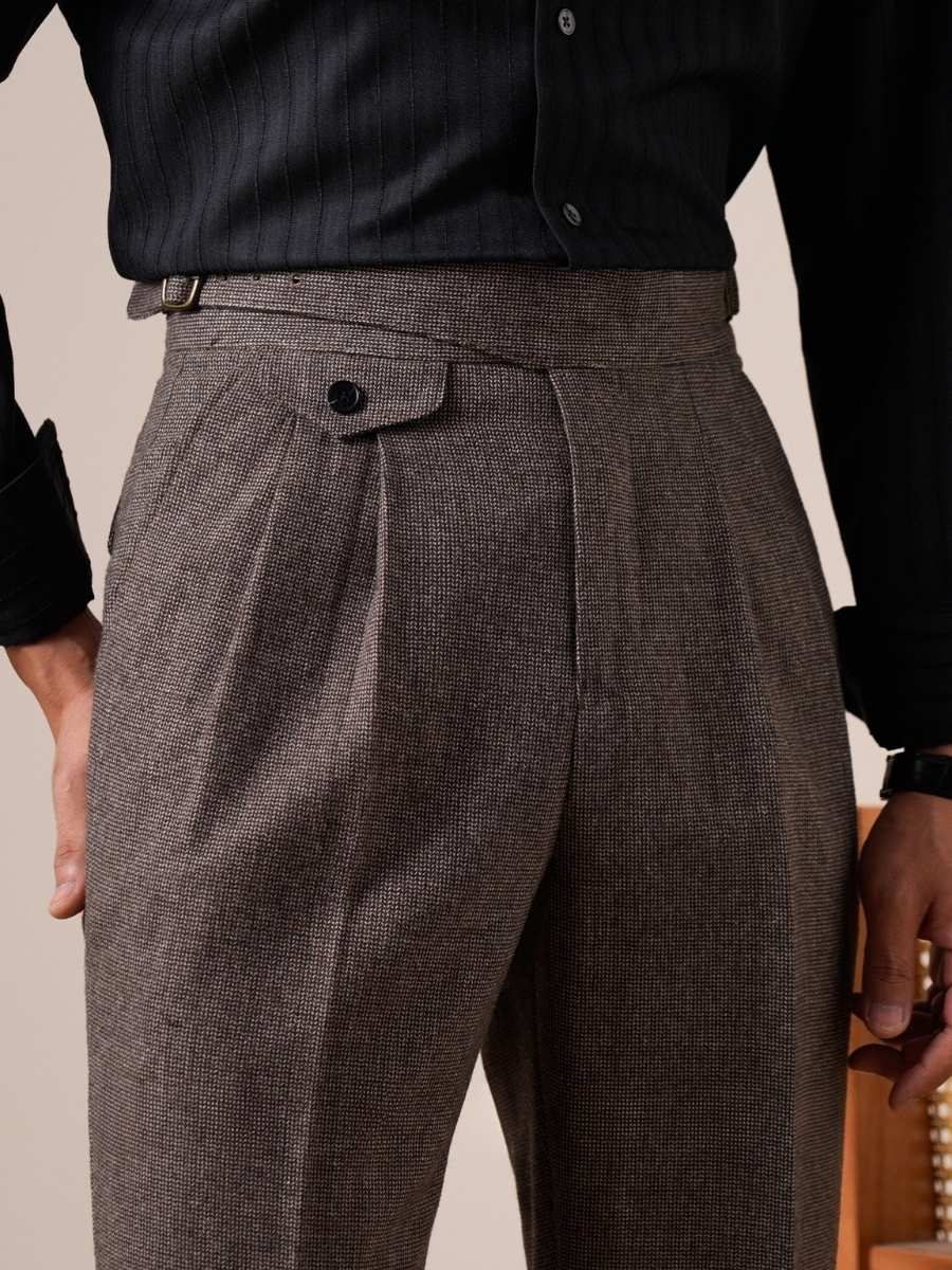 Close-up of men&#39;s brown textured dress trousers with high waist and button details